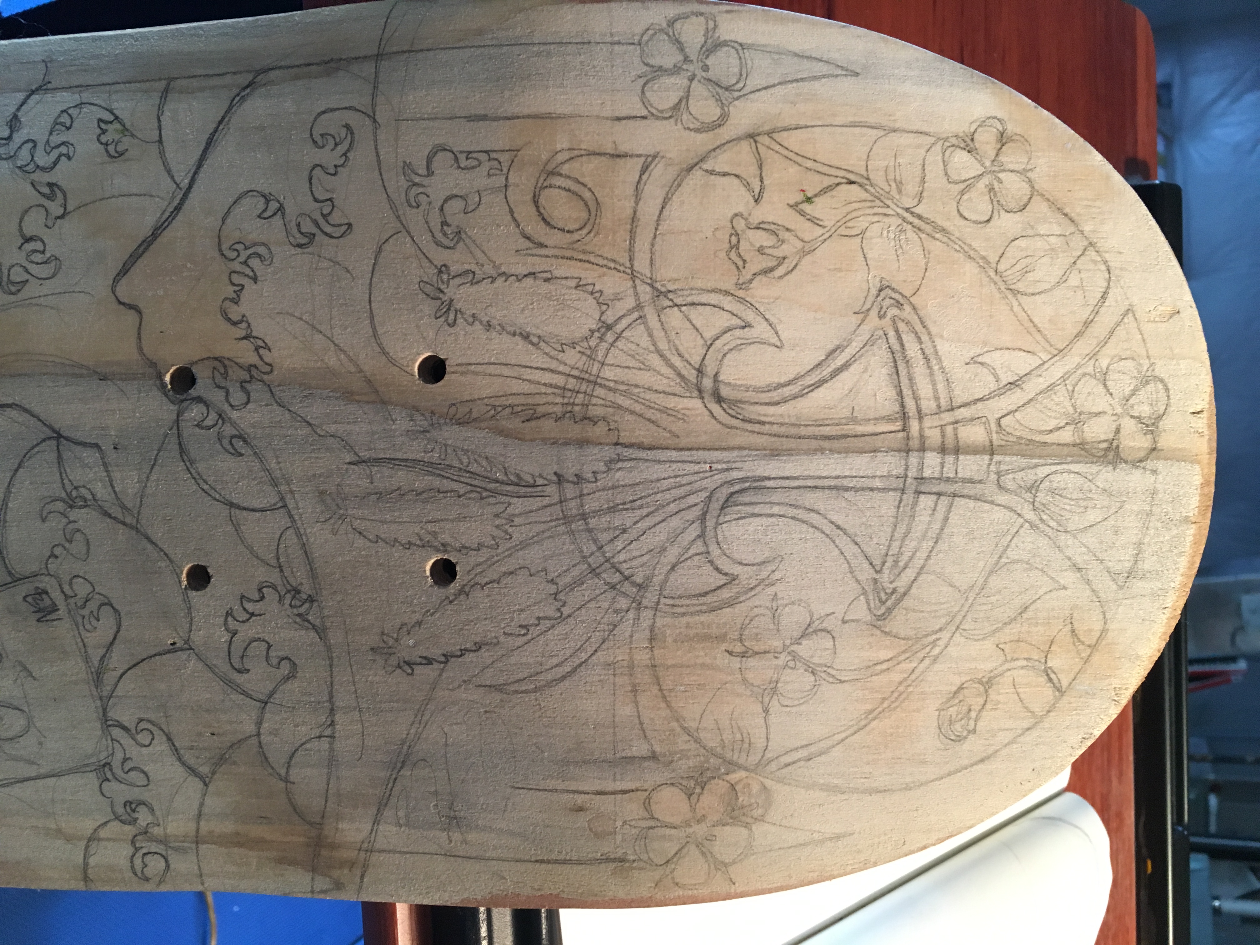 Close up of skateboard before it was painted. There are light pencil sktches on it